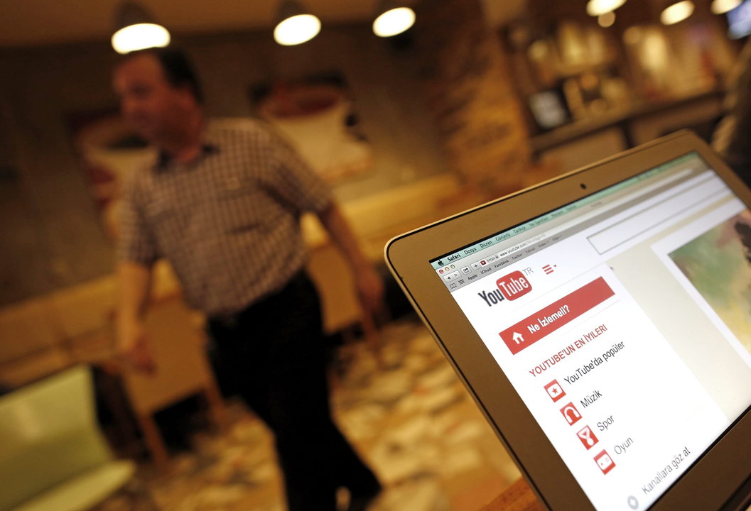 Un ciudadano pasa cerca de un ordenador en cuya pantalla se muestra la página de youtube en un Café de Estambul