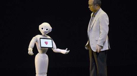 El presidente ejecutivo y presidente de SoftBank, Masayoshi Son, interactua con el robot humanoide &#34;Pepper&#34; durante su presentación en una rueda de prensa