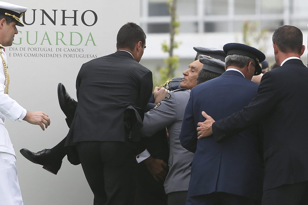 Agentes de seguridad ayudan al presidente portugués Anibal Cavaco Silva al desmayarse durante su discurso en una de las ceremonias del Día de Portugal en Guarda