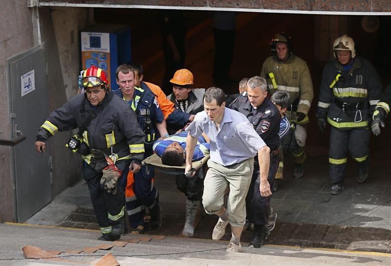 Miembros de los servicios de Emergencias llevan en camilla a un joven que resultó herido al descarrilar tres vagones de un tren del metro de Moscú