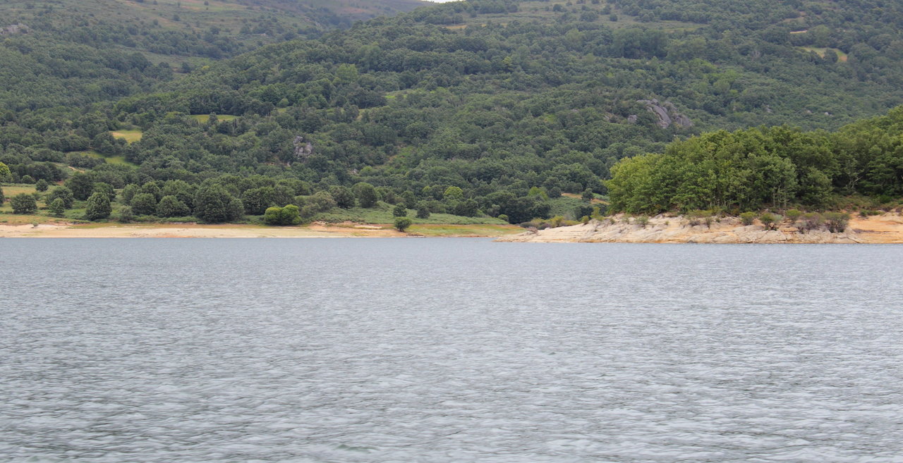 La senda del Xares vista desde el lago formado por el embalse de Prada