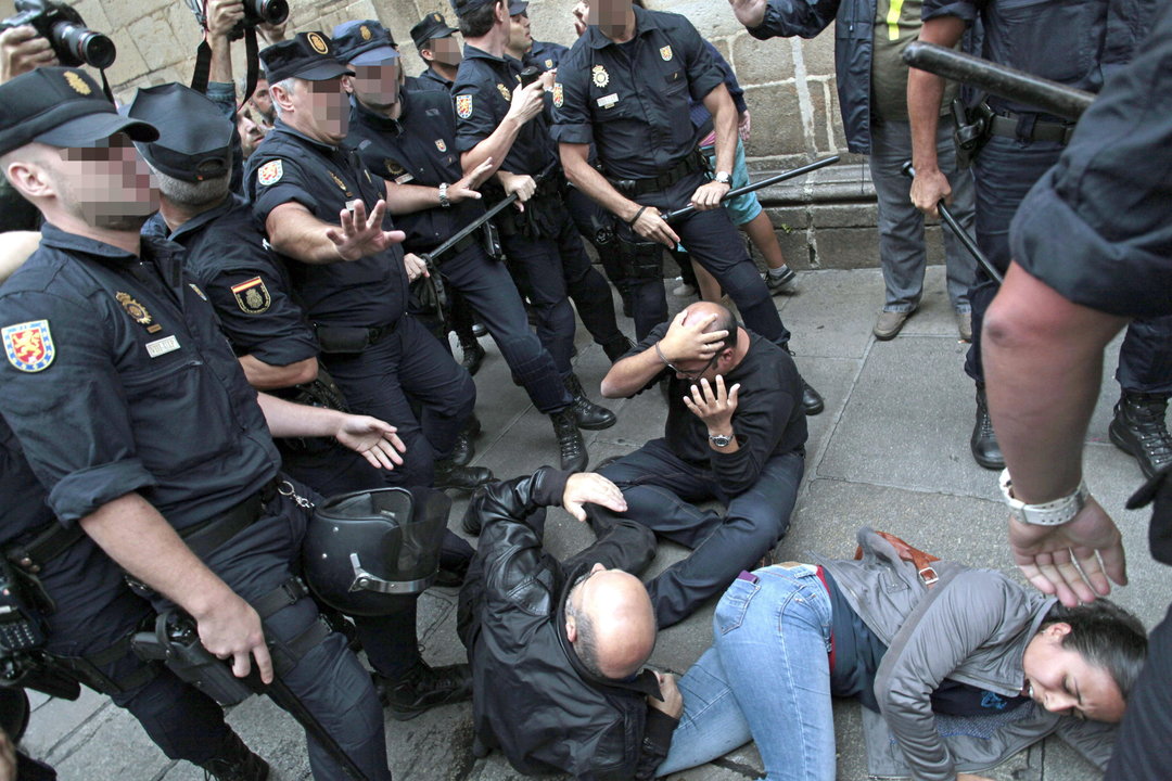  Tres de los manifestantes congregados esta mañana en la plaza de La Quintana, en el casco histórico de Santiago de Compostela, caen al suelo llegando a recibir un porrazo, tras un forcejeo con agentes de la Policía Nacional 