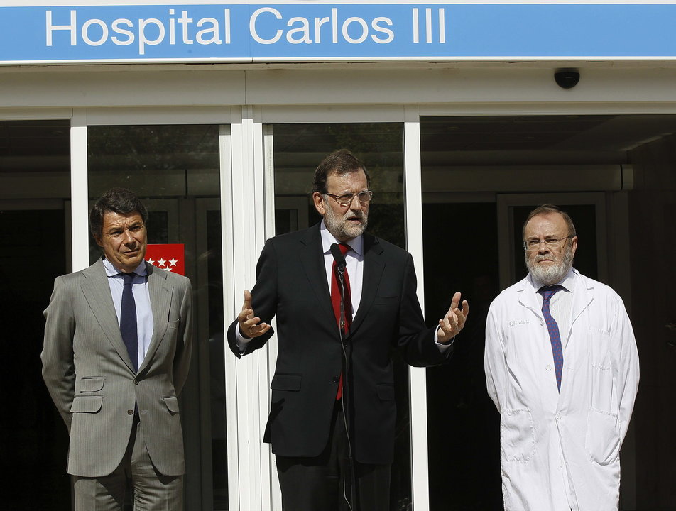 El presidente del Gobierno, Mariano Rajoy (c), que acudió hoy al hospital Carlos III, en declaraciones a los medios de comunicación
