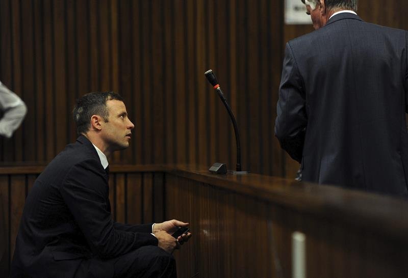 El atleta paralímpico sudafricano Oscar Pistorius (izq) conversa con uno de sus abogados a su llegada al Tribunal Superior de Justicia de Pretoria 