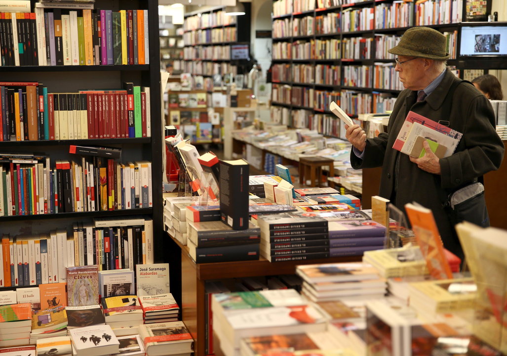 Una hombre hojea unos libros hoy en la librería la Central de Barcelona, en el Día de las Libreríasn (EFE: Toni Albir)