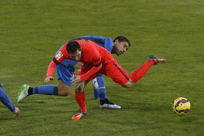  El delantero argentino del Barcelona Lionel Messi cae ante el defensa uruguayo del Getafe Emiliano Velázquez