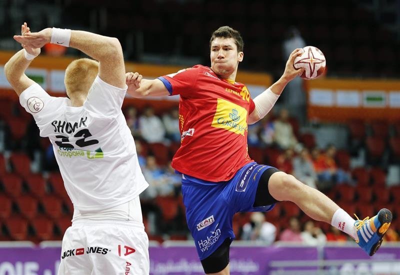 El jugador de la selección española de balonmano, Alex Dujshebaev (d), realiza un lanzamiento durante el partido del Grupo A entre España y Bielorrusia del Mundial de Balonmano de Catar en Doha