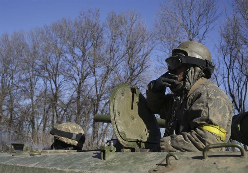 Un soldado ucraniano fuma un cigarrillo desde un tanque mientras abandona la ciudad de Debáltsevo