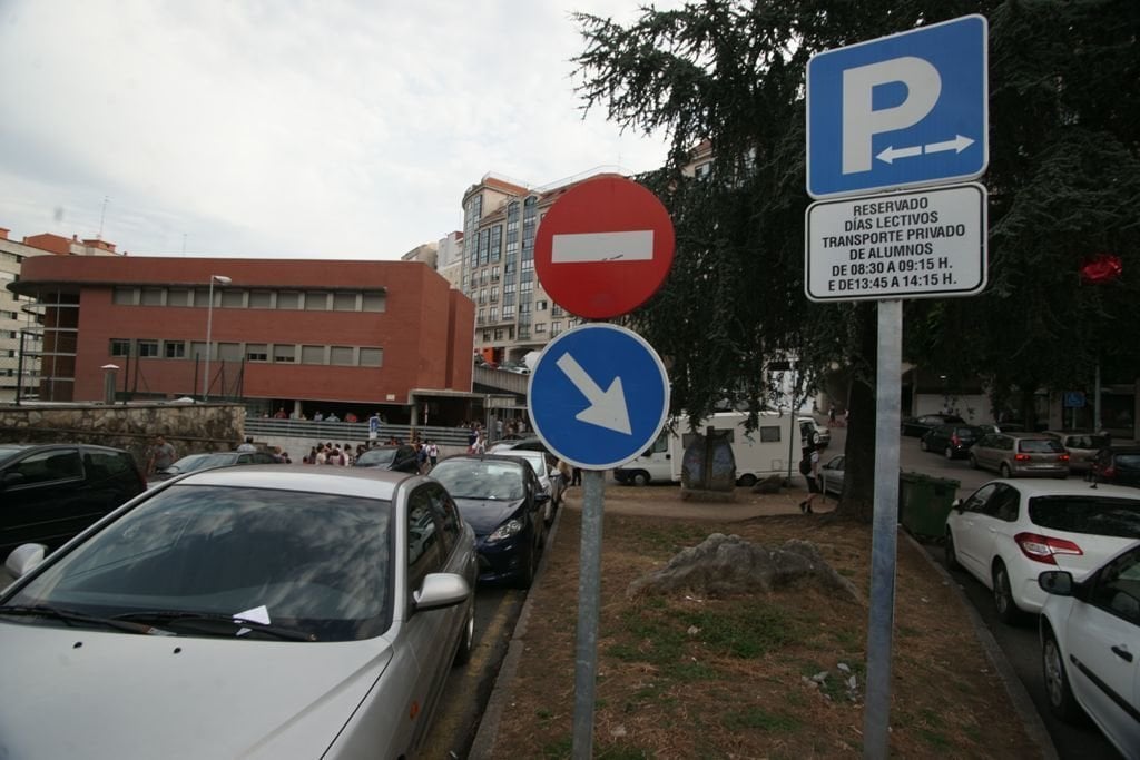 Las señales limitan el estacionamiento en zona escolar.