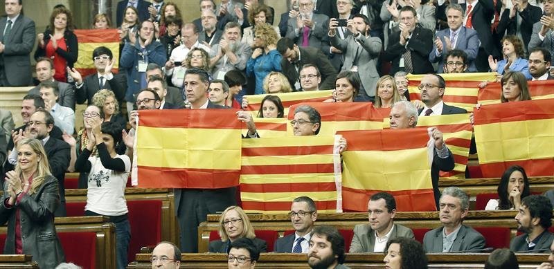Los diputados del Partido Popular de Cataluña se levantan con banderas catalanas y españolas en el momento de la votación.