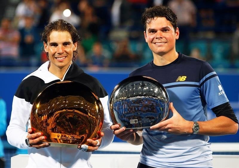 Nadal y Raonic posan con sus respectivos trofeos tras la final de Abu Dhabi.