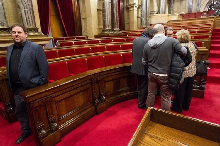 Junqueras se aleja del corrillo en el que habla Artur Mas, esta mañana en el Parlament.