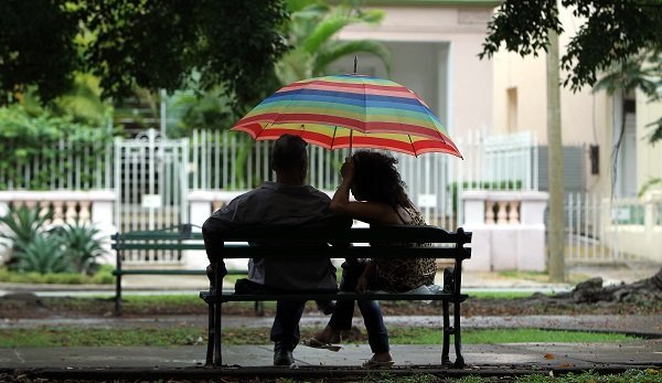 HAB01 LA HABANA (CUBA) 04/06/13.- Una pareja conversa bajo la lluvia en el banco de un parque en La Habana (Cuba), hoy martes 4 de junio de 2013. EFE/Alejandro Ernesto
