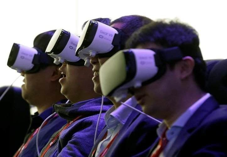 Varios asistentes al Congreso Mundial de Móviles (MWC) que se celebra en el recinto ferial de Gran Vía de L&#39;Hospitalet (Barcelona) prueban el casco de realidad virtual Gear VR de Samsung.