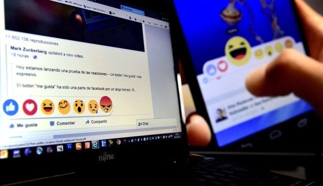 A picture taken on October 9, 2015 in Madrid shows a computer screen displaying the Facebook webpage with the new "Reactions" options as an extension of the "like" button, to give people more ways to easily signal how they feel. Facebook will begin testing this new feature allowing users in Ireland and Spain to express a range of emotions on posts starting today, but there will be no "dislike" button, the social network said.  AFP PHOTO / GERARD JULIEN