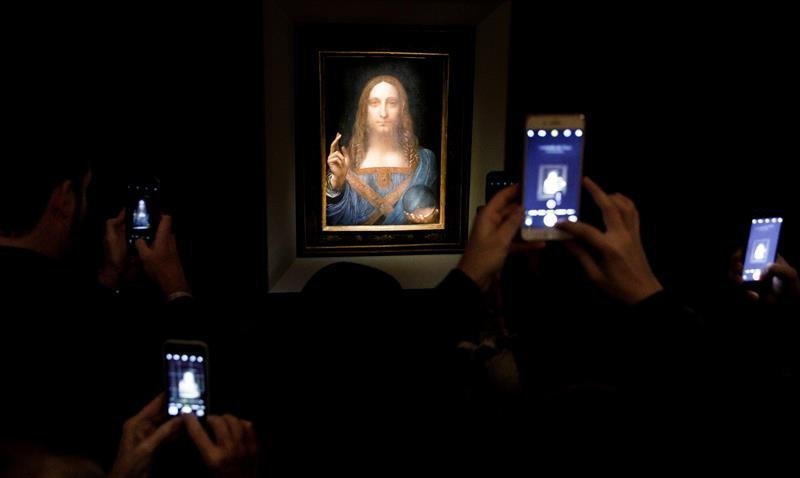 Varias personas fotografían la obra &#39;Salvator Mundi&#39; del artista Leonardo da Vinci (1500)