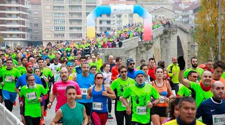 Los corredores de la pasada edición de la San Martiño, a su paso por la Ponte Romana de Ourense.