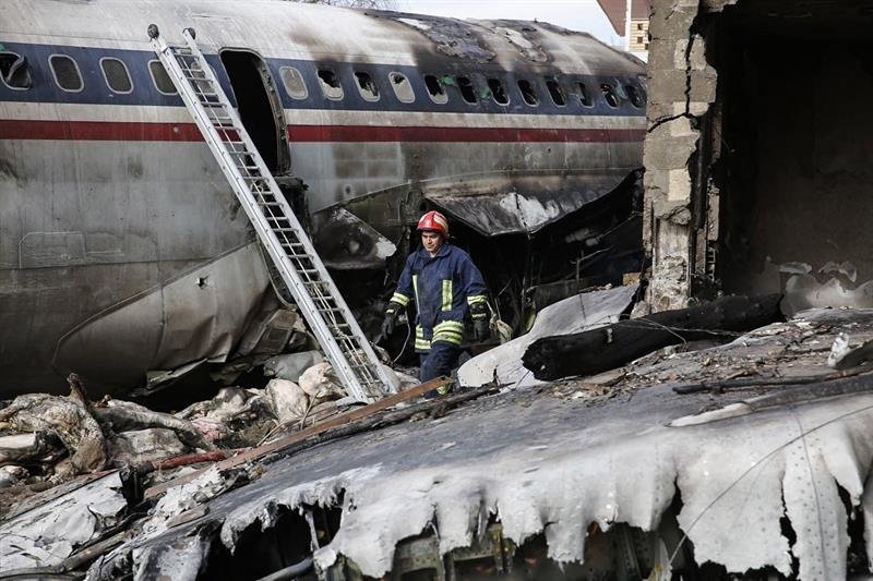 Un bombero camina entre los restos del fuselaje del avión accidentado en Irán.