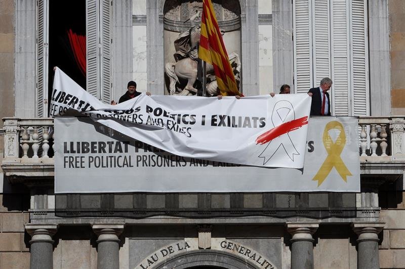 Momento en el que retiran una pancarta y colocan la otra en la Generalitat.