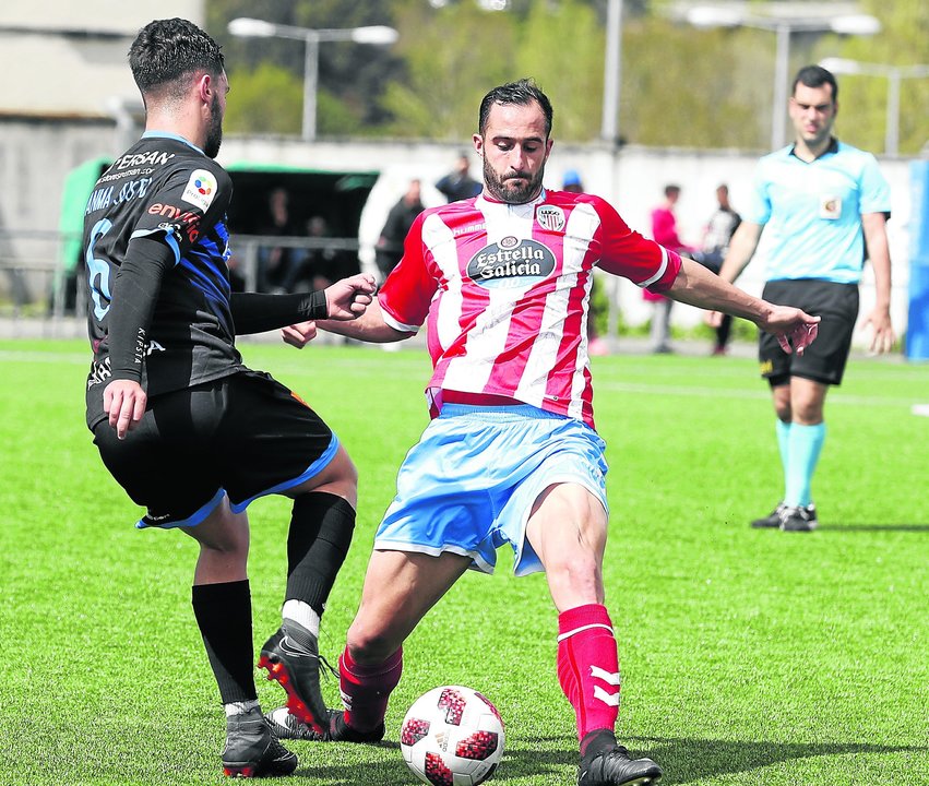 El medio del Ourense CF Juanma Justo pugna por un balón con Cuadrado, del Lugo B.