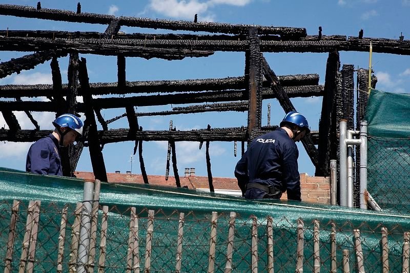 Dos policías revisan parte de la estructura de madera carbonizada por las llamas  (MIGUEL ÁNGEL).