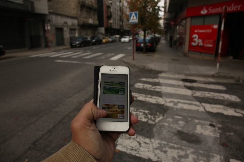 Un viandante muestra las tarjetas de crédito que lleva asociadas a su teléfono móvil (JOSÉ PAZ).