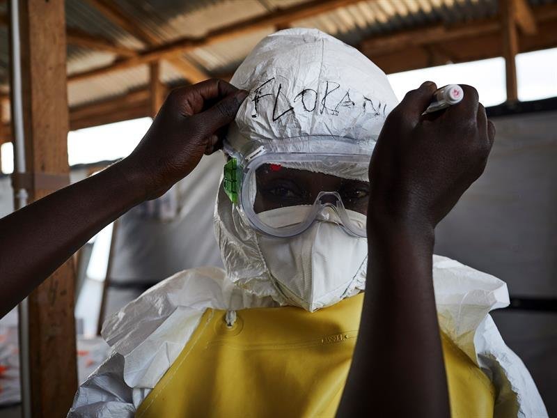 A health worker gets dressed in a protective equipment before moving into the high risk patient zone of an Ebola transit center in Beni, North Kivu province