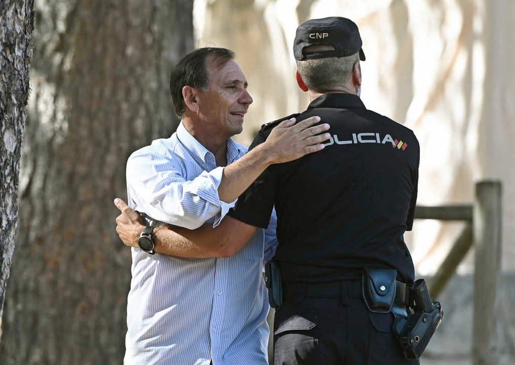 El cuñado de Blanca Fernández Ochoa y portavoz de la familia, Adrian Federighi (i), saluda a un policía antes de declarar ante los medios de comunicación