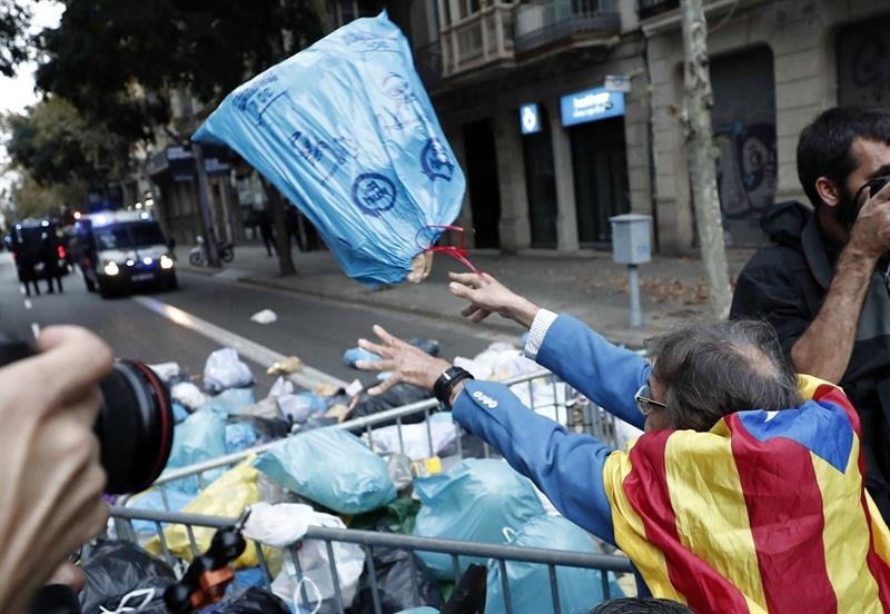Centenares de personas arrojan bolsas de basura ante la Delegación del Gobierno, en Barcelona. (Foto: EFE)