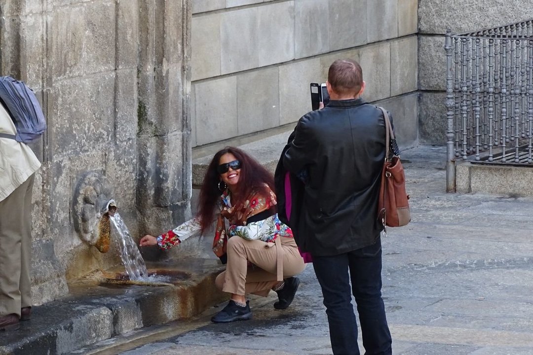 Una pareja de turistas disfruta de las aguas de As Burgas e inmortaliza el momento con su teléfono. (Foto: Martiño Pinal)