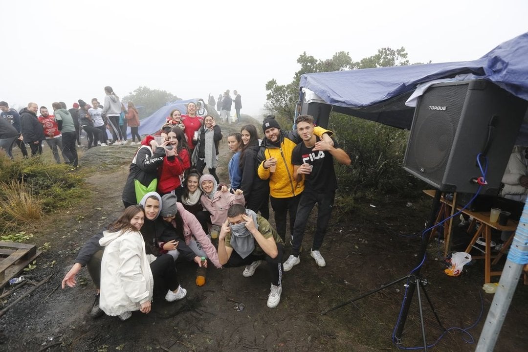 Un grupo de amigos posa frente al chiringuito del DJ de la fiesta del magosto,               en la parte más alta de Montealegre, este sábado al mediodía (XESÚS FARIÑAS).