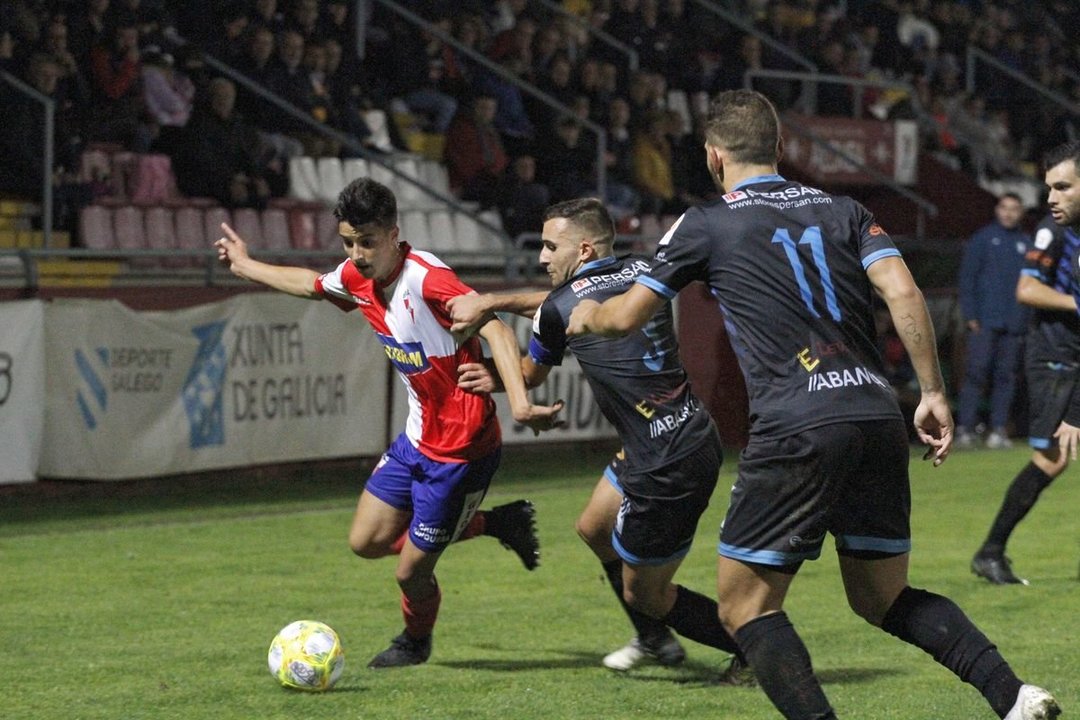 Germán Novoa y Murilo, del Ourense CF, intentan frenar al jugador local Julio Rey ayer en A Lomba (MÓNICA FERREIRÓS).