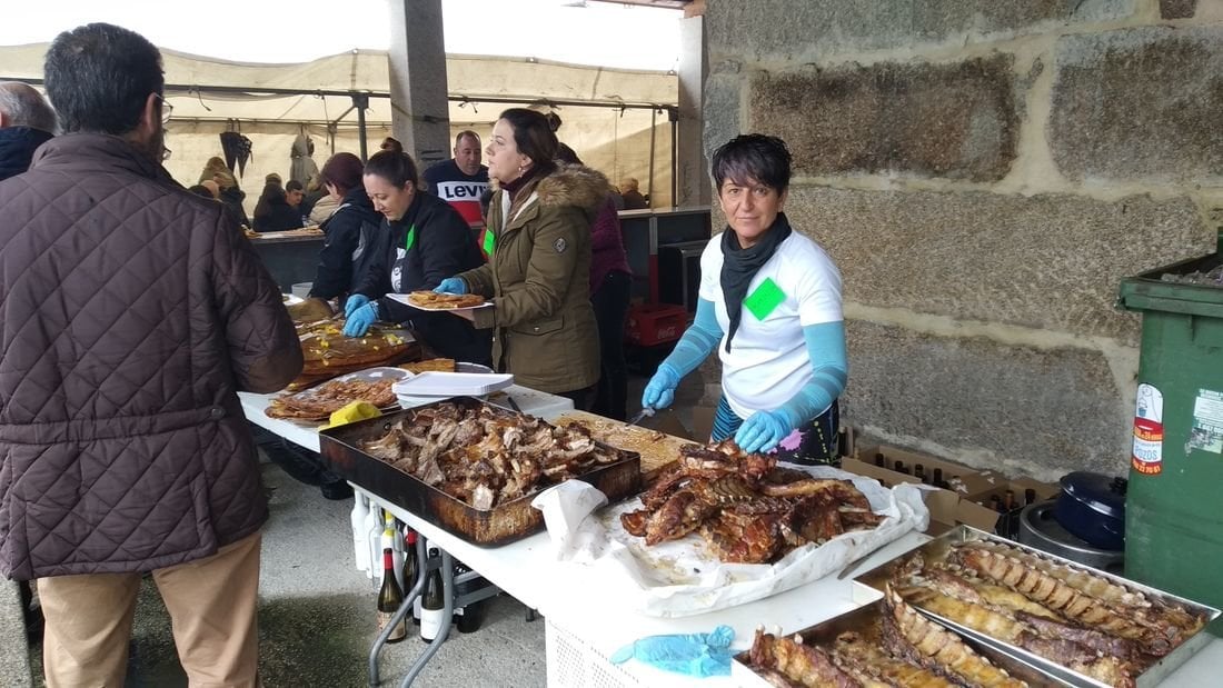 Los organizadores del magosto de Melias, disponiendo la carne y los chorizos para servir a los comensales.