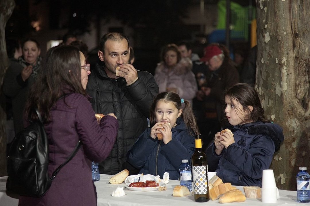 Una familia comiendo a dos carrillos los sabrosos chorizos en el magosto ribadaviense (MIGUEL ÁNGEL).