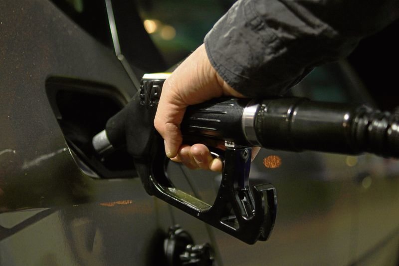 Un hombre reposta combustible para su automóvil en una estación de servicio.