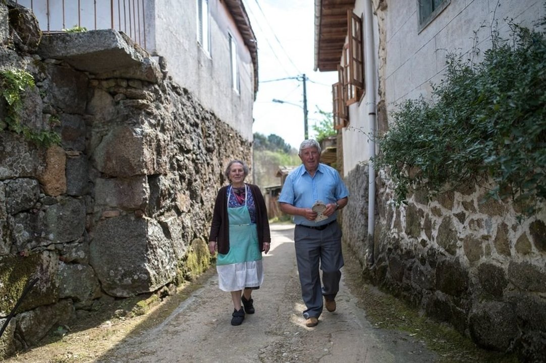 Dos vecinos pasean por las calles de la aldea de O Bagullo, en Cartelle. (Foto: Óscar Pinal)