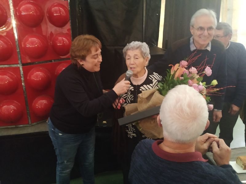 La homenajeada Inés Siso Fernández recibe un ramo de flores.