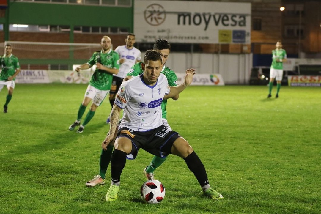 El jugador del Ourene CF Murilo trata de aguantar la pelota ante la oposición del defensa Pol. (Foto: Iván Dacal)