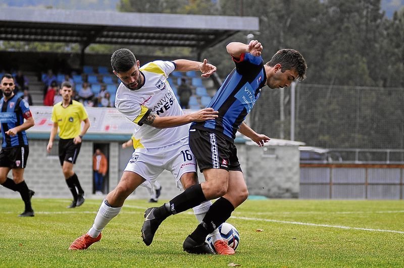 El delantero del Atlético Arnoia, Roberto, lucha por un balón con el centrocampista del Céltiga, Lezcano, en el campo de A Queixeira.