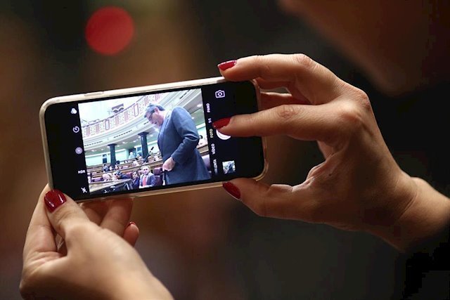 Una mujer emplea un iPhone para sacar una foto en el Congreso de los Diputados. (Foto: Europa Press)