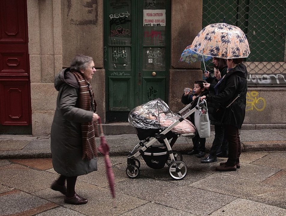 Unos vecinos pasean por el centro de la ciudad con dos niños pequeños. (Foto: Miguel Ángel)
