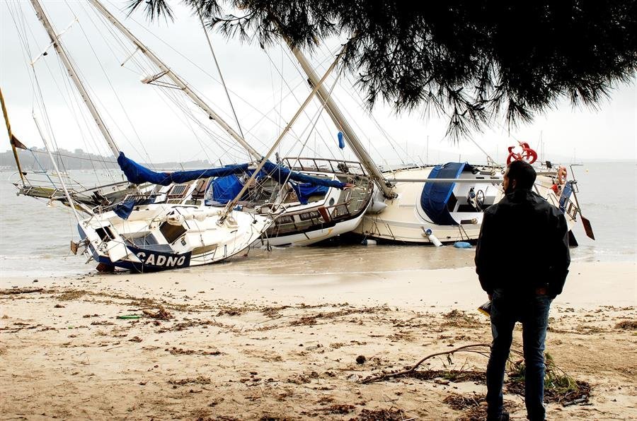 Un hombre mira tres embarcaciones varadas en Mallorca (EFE).