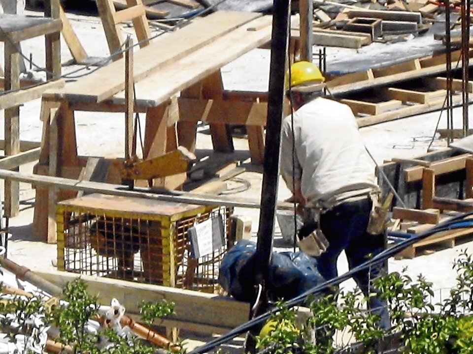 Un operario prepara materiales para utilizar en una obra en construcción.