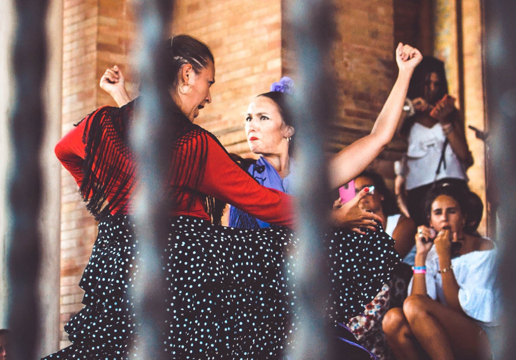 Dos bailaoras flamencas practican ante la mirada de un grupo de transeúntes. (Foto: Unsplash)