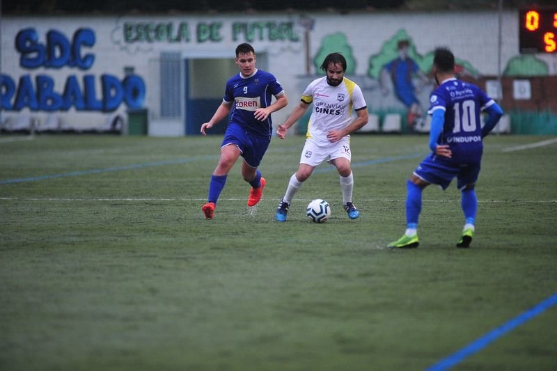 El defensa del Atlético Arnoia, Pablo Roca, controla el balón ante los delanteros Enrique Veras y Tubo, del Porriño Industrial, en un partido disputado en el campo de O Xeixo (JOSÉ PAZ).