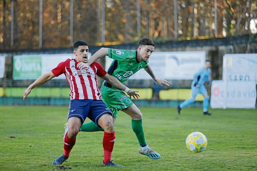El defensa del Arenteiro Toño pelea por una pelota con un delantero del Alondras durante un partido jugado en Espiñedo. (Foto: José Paz)