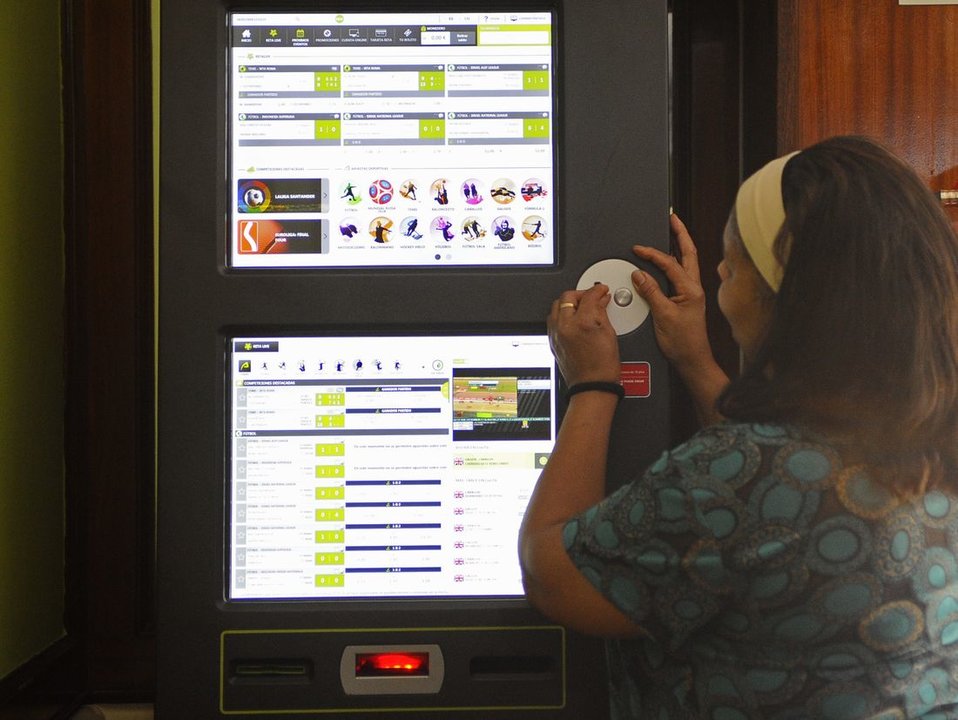 Una mujer introduce dinero para apostar en una máquina de un bar de la ciudad. (Foto: Martiño Pinal)