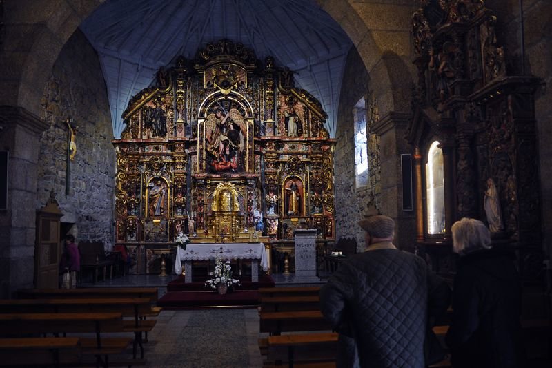 Varios vecinos observan atentamente el restaurado retablo mayor, este miércoles (MARTIÑO PINAL).