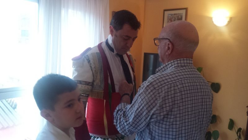 Miro Fernández, ayudado por su padre y su hijo, poniéndose el traje de peliqueiro.