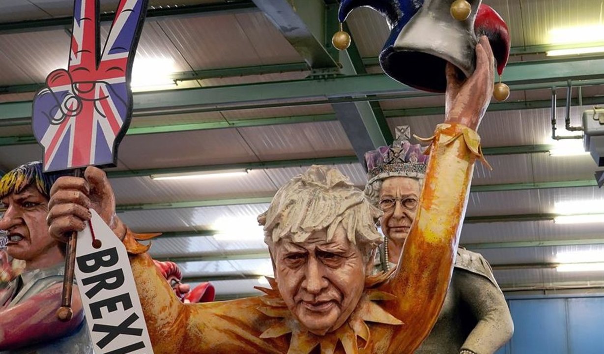 Una figura del Carnaval de Mainz presenta al primer ministro británico Boris Johnson con un letrero de Brexit y un sombrero agachado frente a la Reina